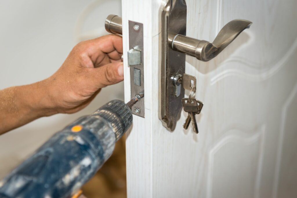 A locksmith drills one of the many types of door locks.